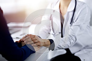 Unknown woman-doctor is reassuring her female patient, close-up. Physician is consulting and giving some advices to a