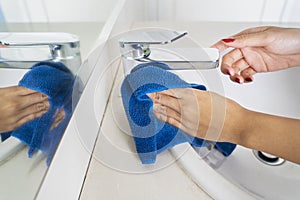 Unknown woman hands cleaning a faucet