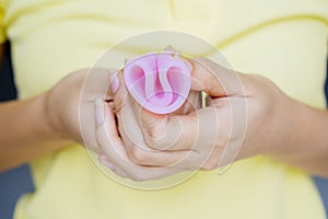 Unknown woman hands folding a menstrual cup