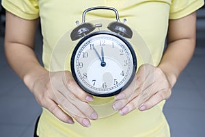 Unknown woman holding an alarm clock