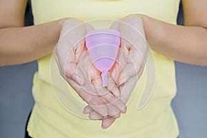 Unknown woman holds a sanitary cup on her palm