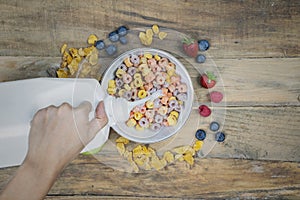 Unknown woman pouring milk into a cereal