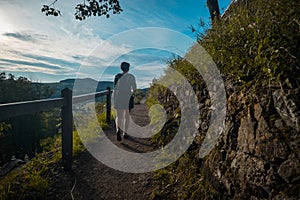 Unkown female walking up the path towards the highest part of Banska Stiavnica Calvary during late summer afternoon. Romantic