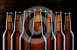 Unlabelled beer bottles on dark background.