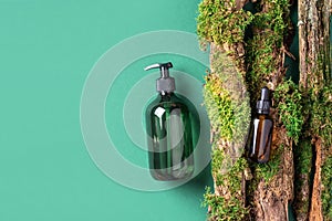 Unlabelled cosmetic bottle on green background, natural moss over branches, bark. Skin care, organic body treatment, spa