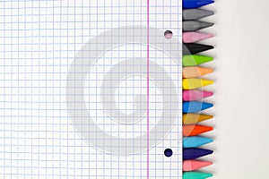 Unlimited creativity: Colored crayons and notebook sheet for colorful back-to-school