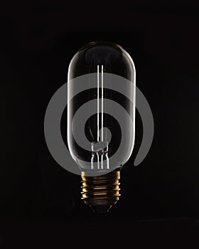 Unlit tungsten filament light bulb on black
