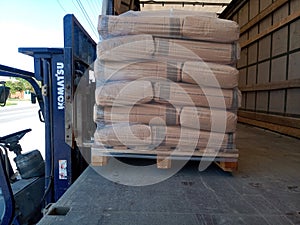 Unloading bags of cement from a truck with a forklift