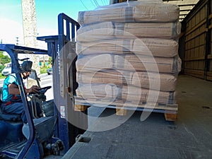 Unloading bags of cement from a truck with a forklift