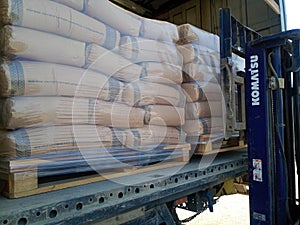 Unloading bags of cement from a truck with a forklift