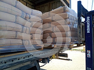 Unloading bags of cement from a truck with a forklift