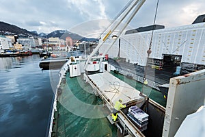 Unloading cargo with a crane on the mailboat MS Lofoten of norwegian coastal line Hurtigruten lying in port in Bergen