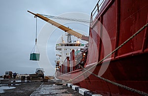 Unloading a cargo ship near the pier
