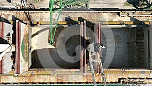 Unloading dry cargo ship by cranes in port. Aerial view cargo hold