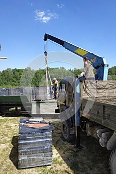 Unloading the front brick using a mobile crane in the village in private territory.