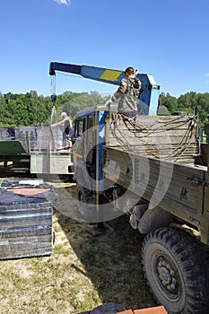 Unloading the front brick using a mobile crane in the village in private territory