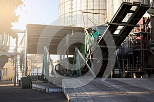 Unloading grain truck at elevator on elevating hydraulic platform unloader. Grain crops transshipment at big sea