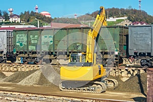 Unloading unloading rubble with an excavator railway carriage wagons with bulk cargo gravel, sand at the station