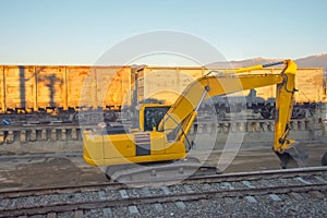 Unloading unloading rubble with an excavator wagons with bulk cargo gravel, sand at the station