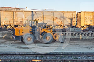 Unloading unloading rubble with an excavator wagons with bulk cargo gravel, sand at the station