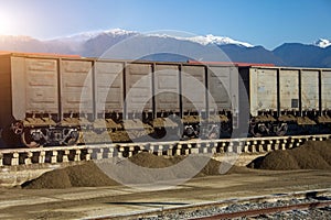 Unloading wagons with bulk cargo gravel, sand at the station