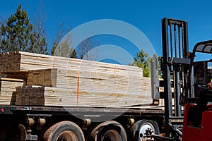An unloading of wooden building materials on a construction site is performed by a lift manipulator