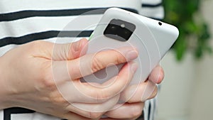 Unlock smartphone with fingerprint, woman holding mobile phone, hands close-up