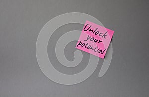 Unlock your Potential symbol. Concept words Unlock your Potential on pink steaky note. Beautiful grey background. Business and