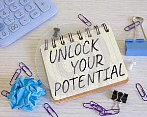 Unlock your Potential symbol. Concept words Unlock your Potential on white notebook. Beautiful wooden background. Business and