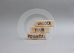 Unlock your Potential symbol. Wooden blocks with words Unlock your Potential. Beautiful grey background. Business and Unlock your