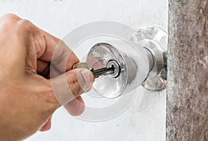 Unlocking door with key in hand