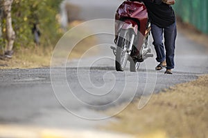 Unlucky man push forward dead motorcycle