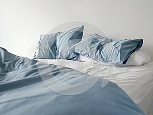 Neustlaný postel pomačkaný modrý postel prádlo 