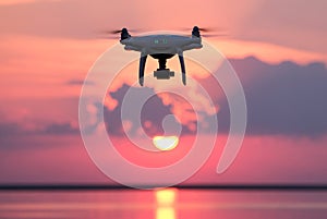 Unmanned aerial vehicle on a background of pink clouds. Silhouette of radio-controlled drone over the water surface at sunset. The