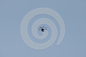 Unmanned aerial vehicle - quad copter with a camera and broadcast video flies in the blue sky