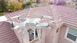 Unmanned Aircraft System UAV Quadcopter Drone In The Air Over House Inspecting the Roof