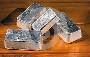 Unmarked silver bars on a against a painted wood