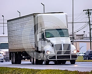 An Unmarked Tractor Trailer Leads Traffic On A Wet Day photo