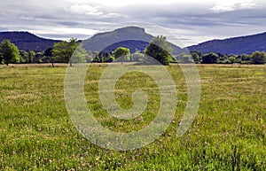 The unmistakable shape of Colle Rousse, Volcanic plug across the fields and meadows of La Plan, Bagnols photo