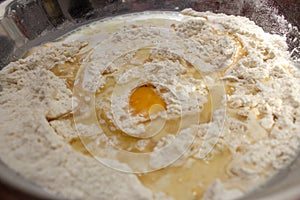 Unmixed ingredients of bread dough: eggs, wheat flour, oil and yeast