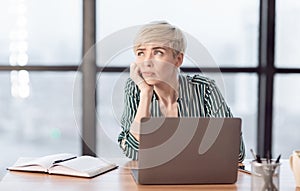 Unmotivated Lady Sitting At Workplace In Modern Office