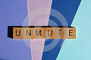 Unmute, word in 3D wooden alphabet letters isolated on colour background
