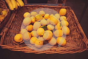 Unpacked organic lemons in basket on display in organic super market.