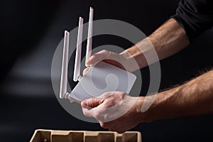 Unpacking new router. White router in hands. Connecting wifi router to network
