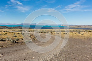 An unpaved road in the desert landscape in El Calafate city, the Lake Argentino and the Lagoon Nimez, Patagonia Argentina.