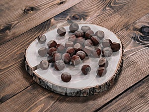 Unpeeled hazelnuts on a cracked wooden stand