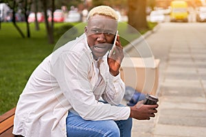 Unpleasant phone call, worried anxious man talking mobile phone sitting bench summer park