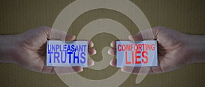 Unpleasant truths versus conforting lies on cardboards in man`s hands photo