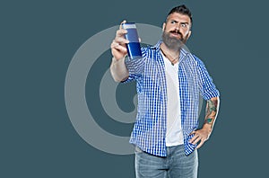 unpleased bearded man hold beauty product bottle of shampoo