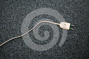 Unpluged lamp cable on the carpet floor. Old lamp cable photo